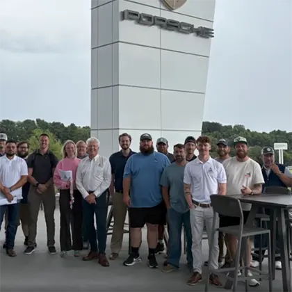 AESSEAL Inc employees stand in front of the Porsche Experience Center in Atlanta.
